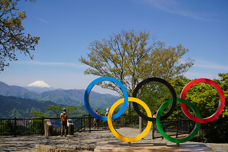 The Olympic symbol has been installed at the summit of Mt. Takao, a popular tourist spot in Tokyo. Visible in the distance is a well-known symbol of Japan: Mt. Fuji.
