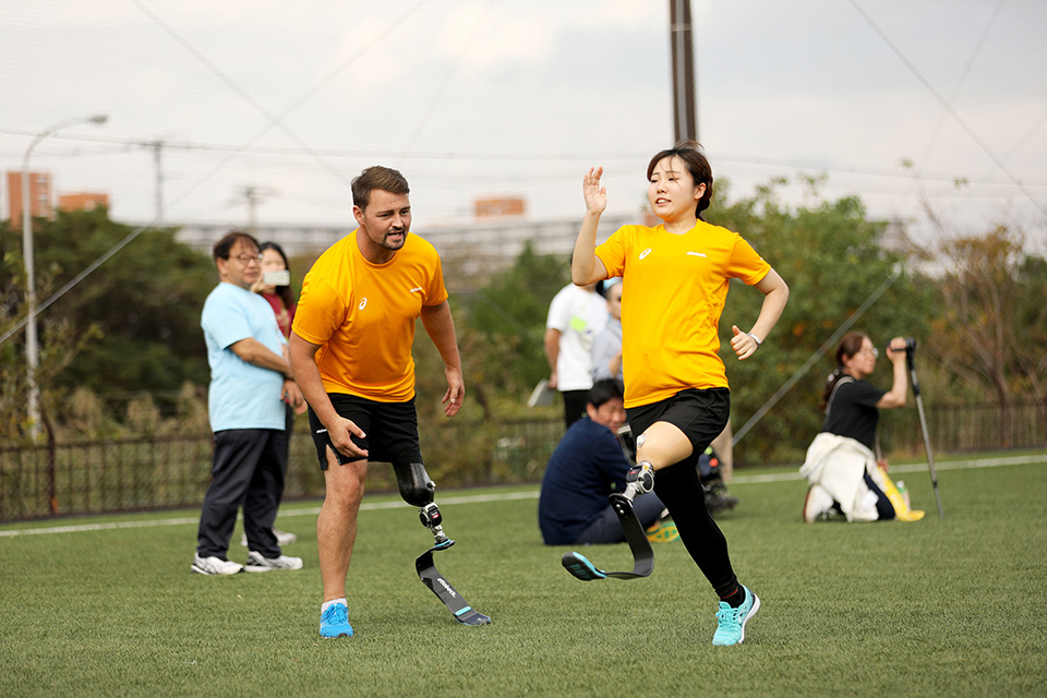 At a running clinic, Popow teaches people how to run using prosthetic legs. Most participants