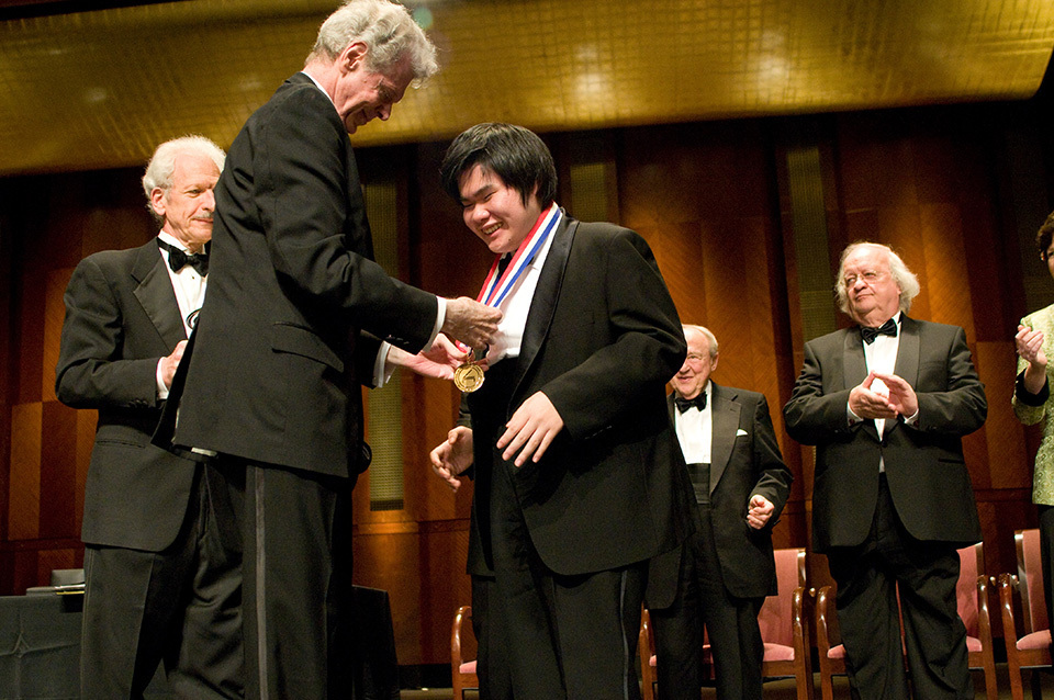 When Tsujii triumphed at the Van Cliburn International Piano Competition in 2009, he received the gold medal from Cliburn himself (left front). The encounter is one of his most treasured memories.   ©Van Cliburn Foundation