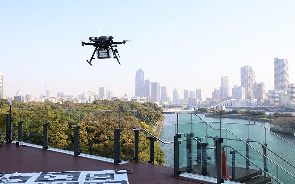 An autonomous drone carries a box containing hot meals for a field test of food delivery in Tokyo in November 2021. AFLO