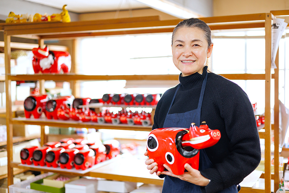 Hayakawa Minako who works based in Fukushima is holding her signature work akabeko, aka means red and beko means cow in Japanese, ornaments. 