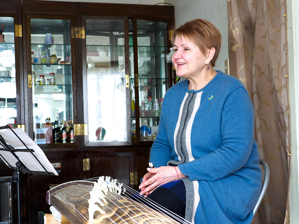 Irina is all smiles as she learns to play the koto, a traditional Japanese zither-like instrument.