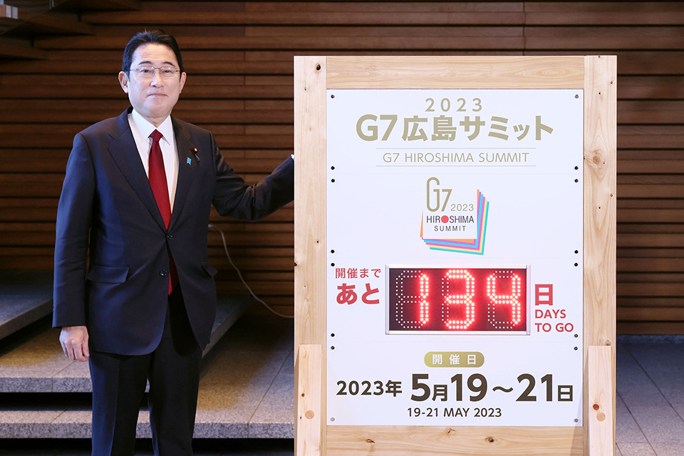 Prime Minister Kishida standing next to the countdown-board  for the G7 Hiroshima Summit.