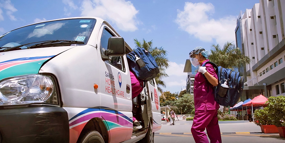 Staff members of home-care service at Sakra World Hospital, getting into a car to visit patients' homes.