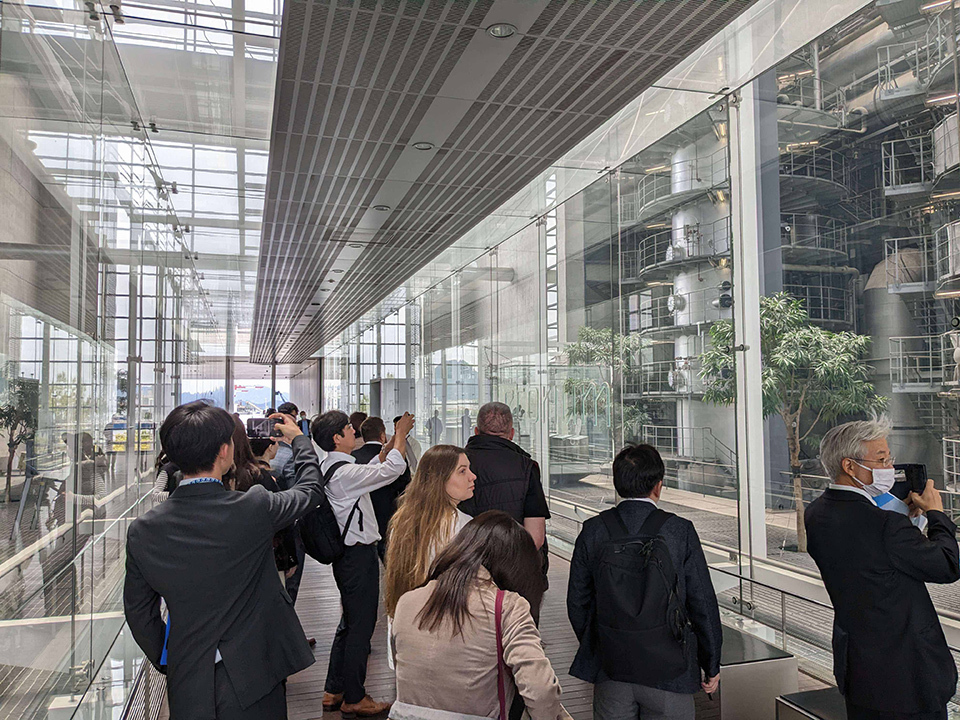 People who tour the inside of the facility. Some of them are taking pictures with their smartphones. NIPPON KOEI CO., LTD.