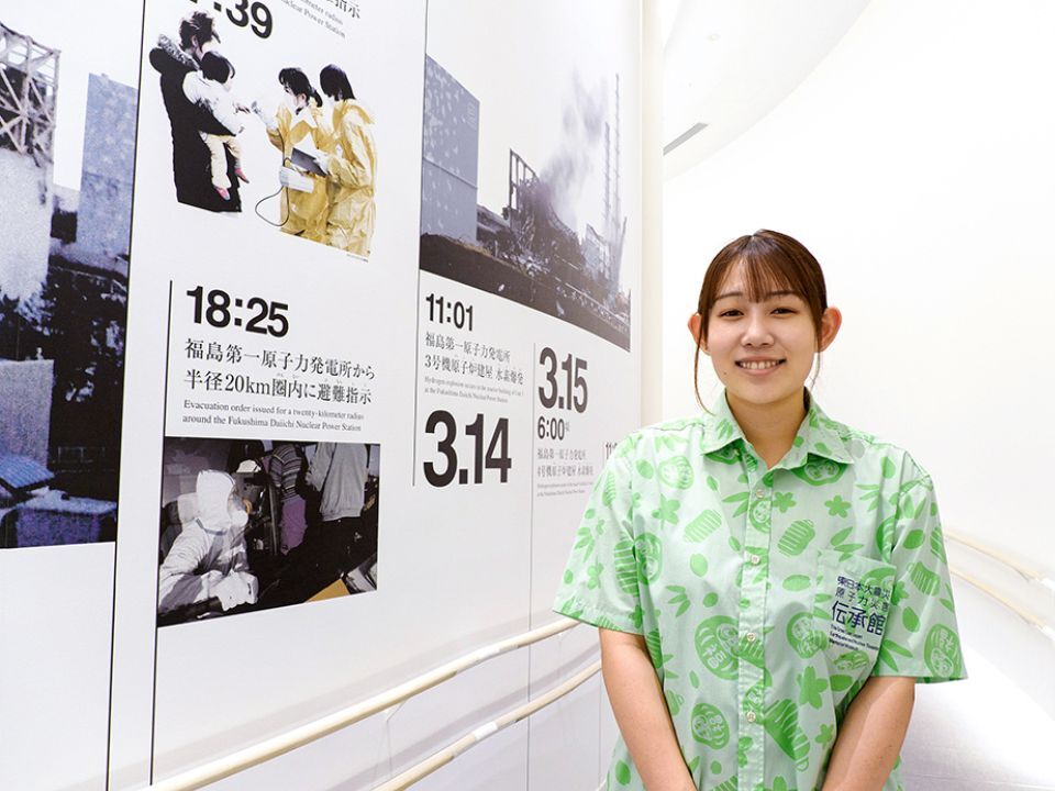 Endo Miku, staff membern and storyteller at the Great East Japan Earthquake and Nuclear Disaster Memorial Museum, standing in front of the exhibition.