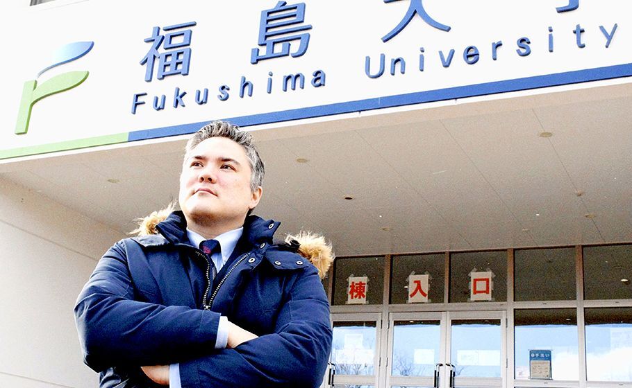 Associate Professor Michael McMichael gazing into the distance at the entrance of Fukushima University building.