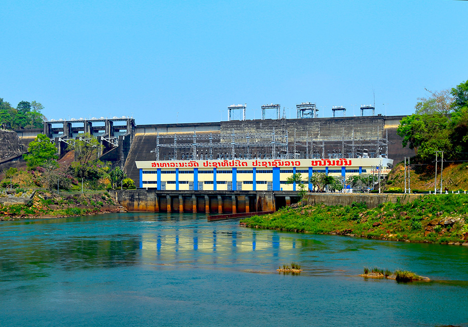 Nam Ngum 1 Hydropower Station in Laos, featuring a building with regular rows of blue columns on ivory walls and pylons above a sluice gate.