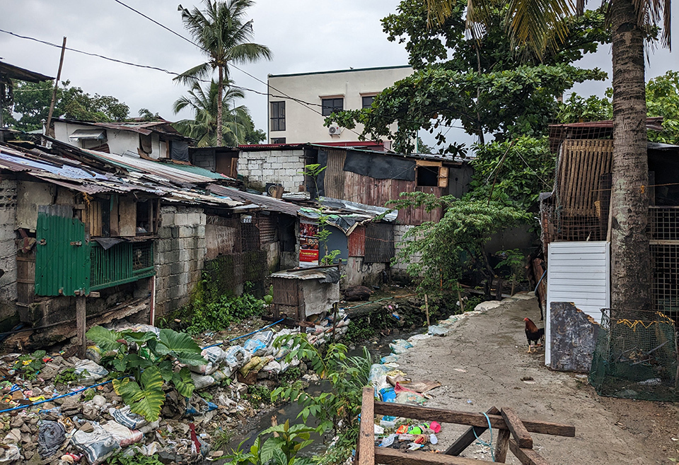 An impoverished settlement in Metro Manila, Philippines, surrounded by garbage and debris.