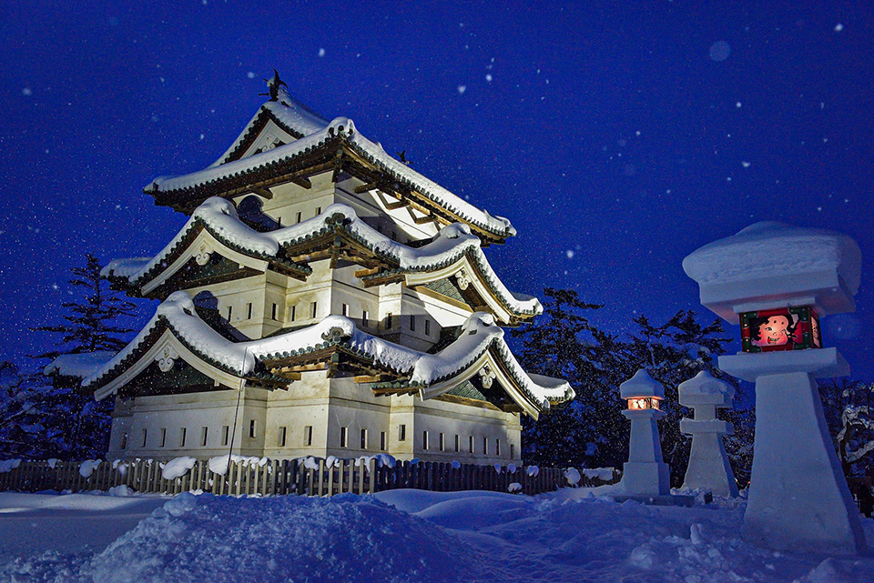 Snowy Hirosaki Castle with small kamakura (snow domes)  and  lanterns.