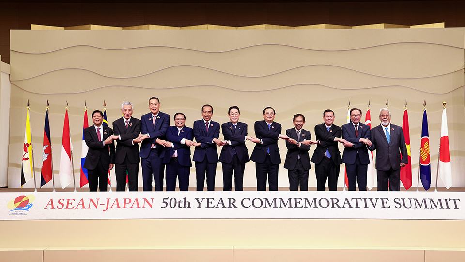 Leaders standing together for a photo at the Summit, with flags of participating nations displayed in the background.