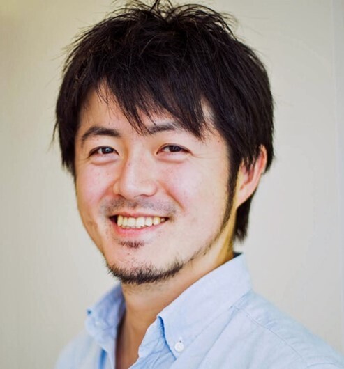 Portrait of a Japanese journalist Furuta Daisuke, white wall in a background.