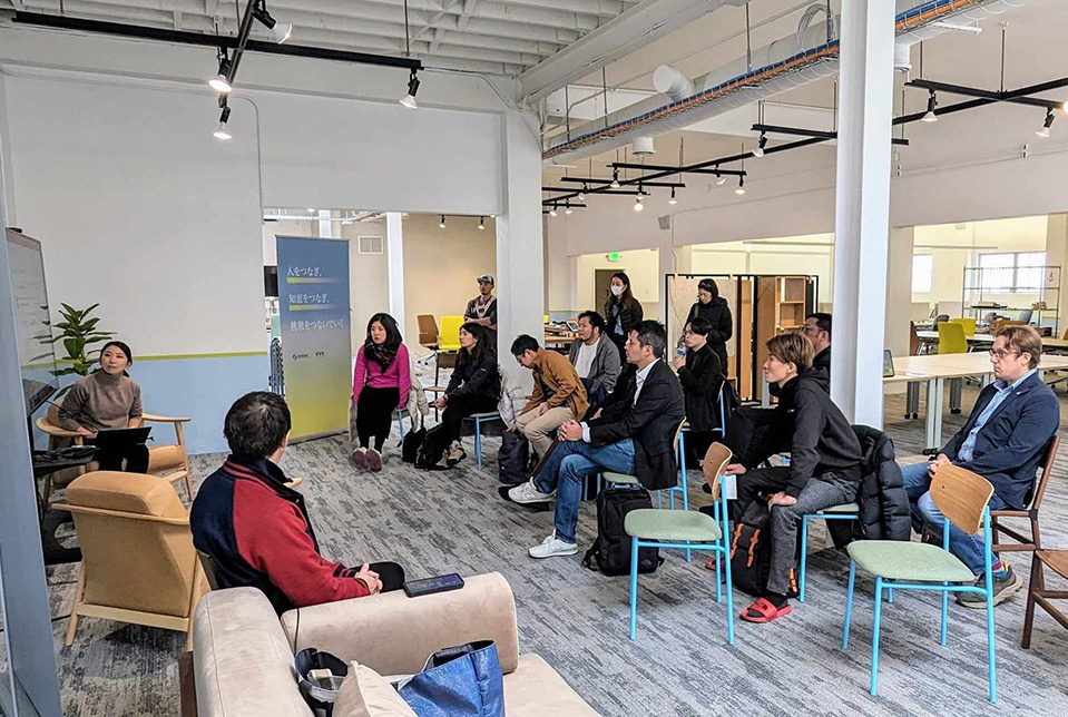 A group of people seated in a well-lit room, attentively listening to a presenter at Japan Innovation Campus.