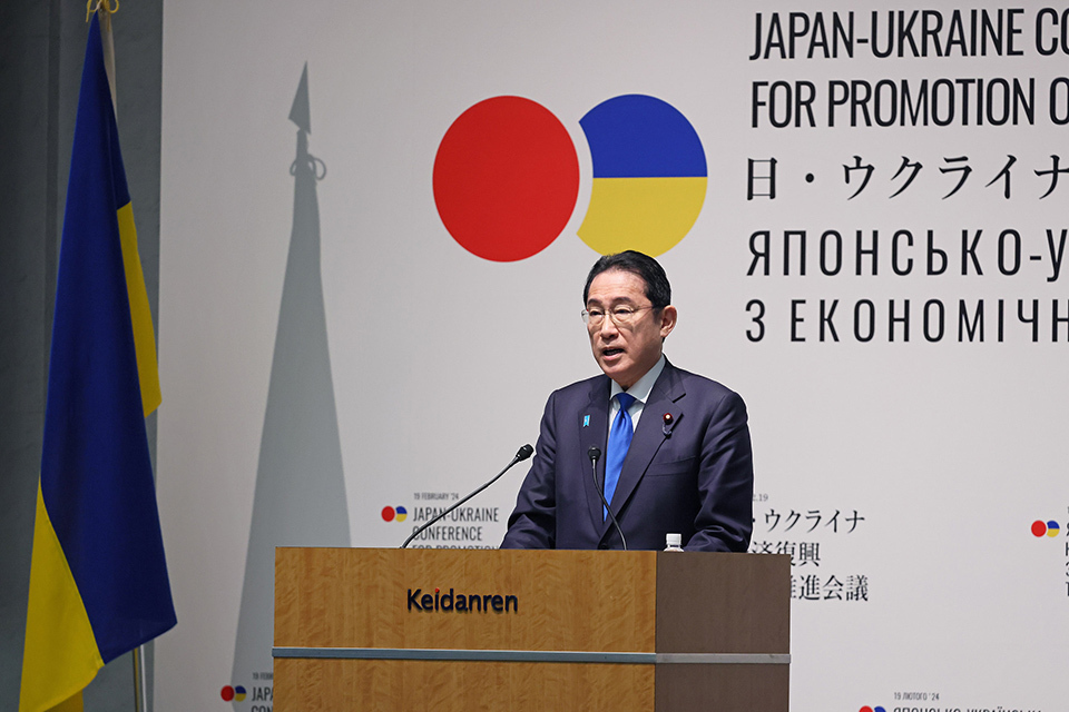 Prime Minister Kishida standing at a wooden podium, giving a speech.