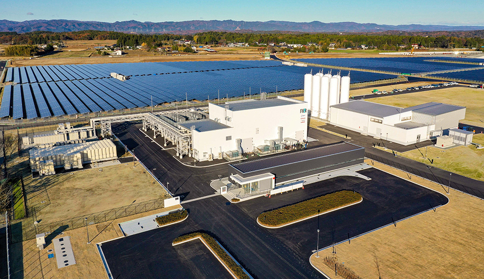 Aerial view of the Fukushima Hydrogen Energy Research Field (FH2R) with rows of solar panels arranged in a grid layout