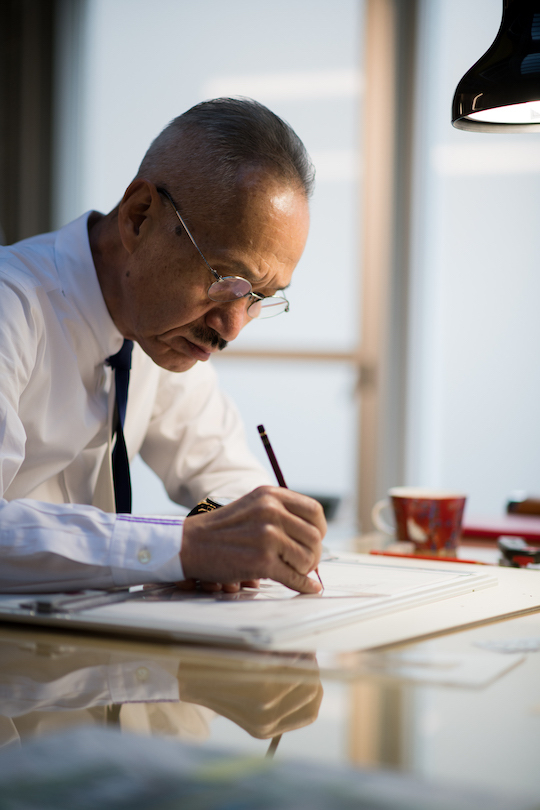 TAKAMATSU Shin is focusing on drawing his architectural idea at a desk.