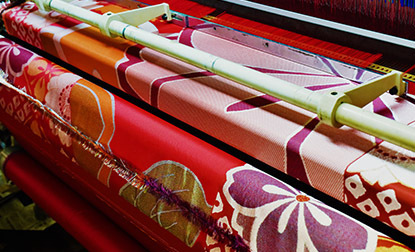 Large fabric rolls are neatly rolled up, showcasing their vibrant Japanese Nishijin pattern, texture and color.