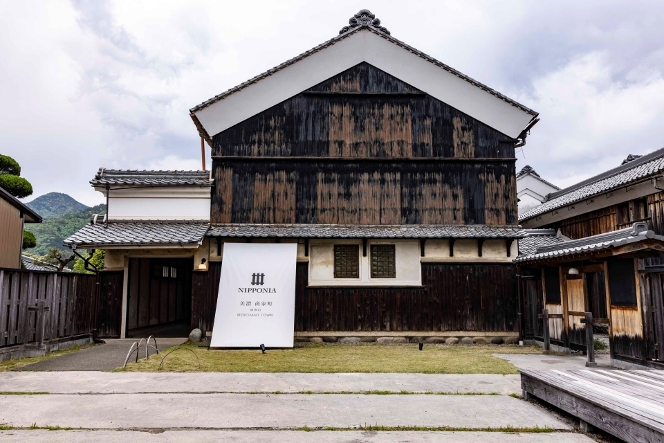 A traditional Japanese warehouse building built from dark wood that has been renovated into a hotel