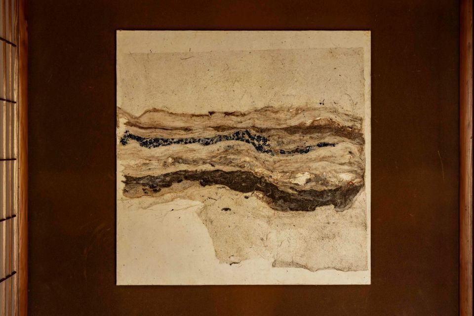 A large piece of art on a dark wall, made from washi paper