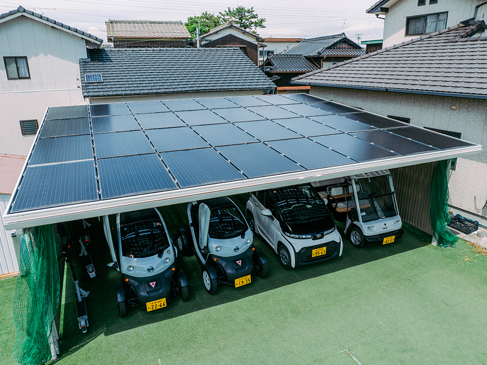 Four EVs charging under a roof of solar panels