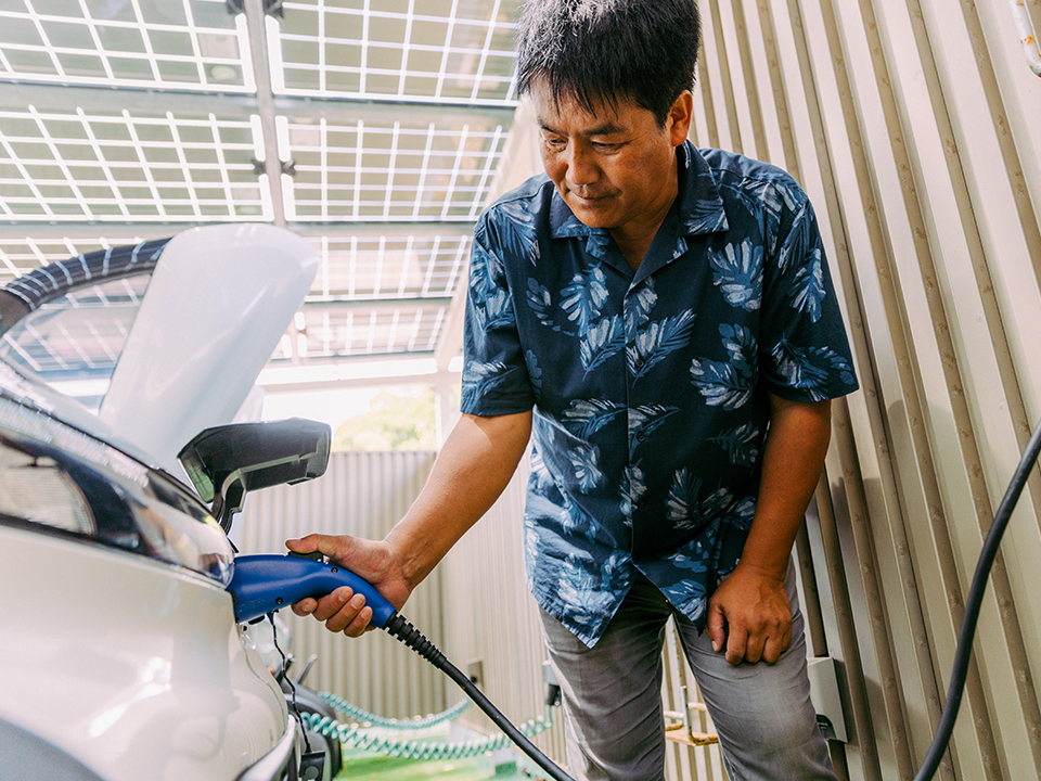 A man charging an electric vehicle