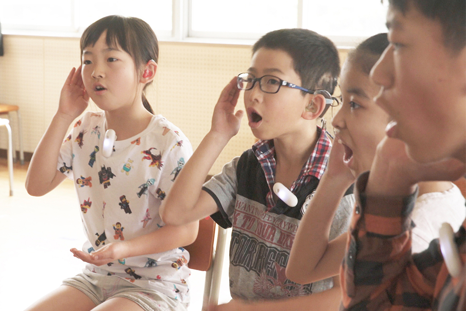 Japanese children at a school for the deaf feeling their own voices using the Ontenna 