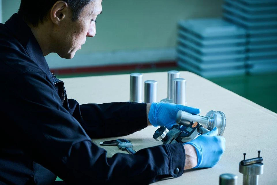 An engineer inspects a Free Piston Stirling Cooler cylinder