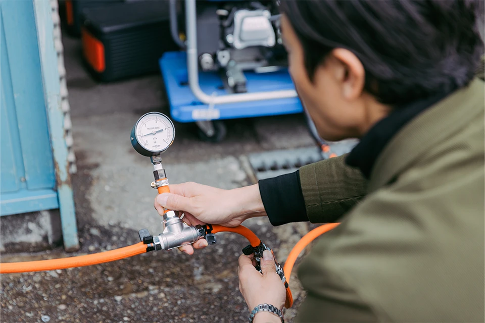 A man checking the production of methane gas created from vegetable scraps