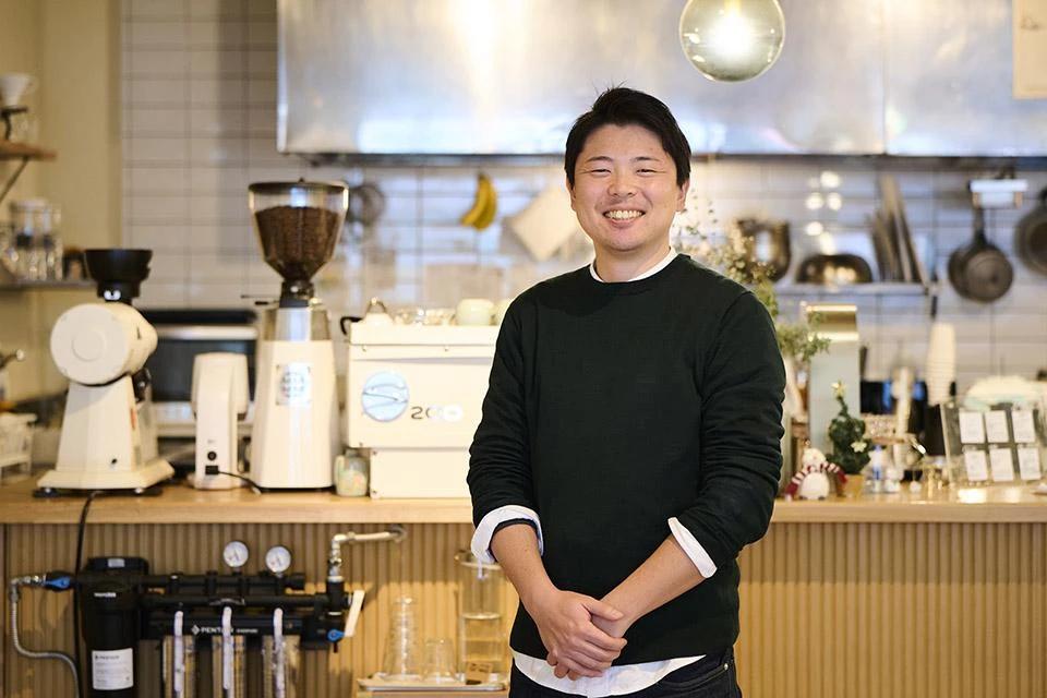 Aoki Nozomu, head of “circulative coffee roaster” Atarao, posing in his coffee shop