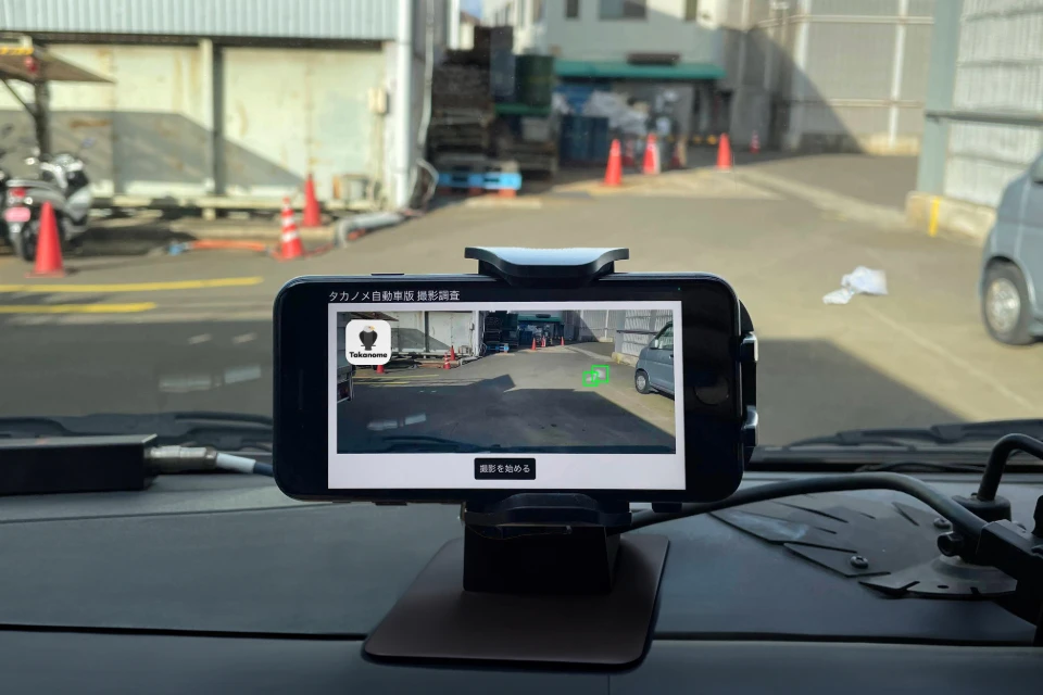 Photo of a smartphone running the Takanome service, which surveys the distribution of litter on streets and roads.