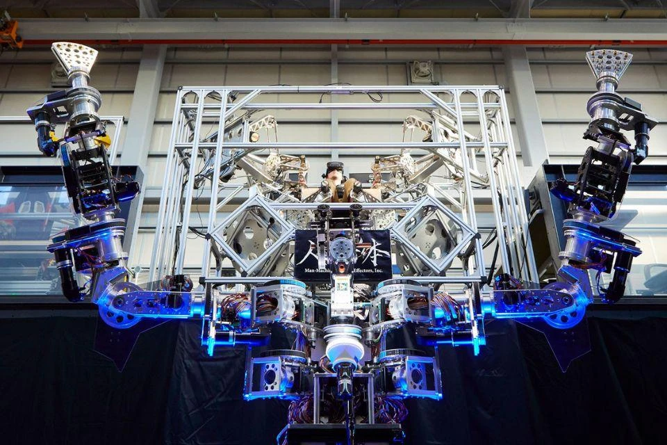 A human operator using VR goggles and control sticks to use a robot