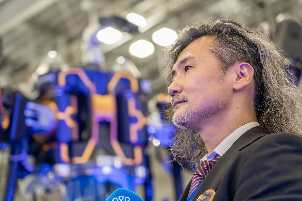 Dr. Kanaoka, president of JINKI-ITTAI, in front of one of this company's robots