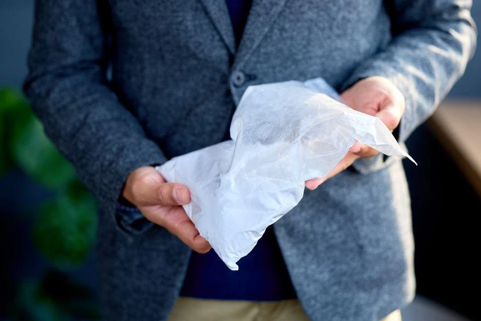A man holding a bag of aluminum hydroxide