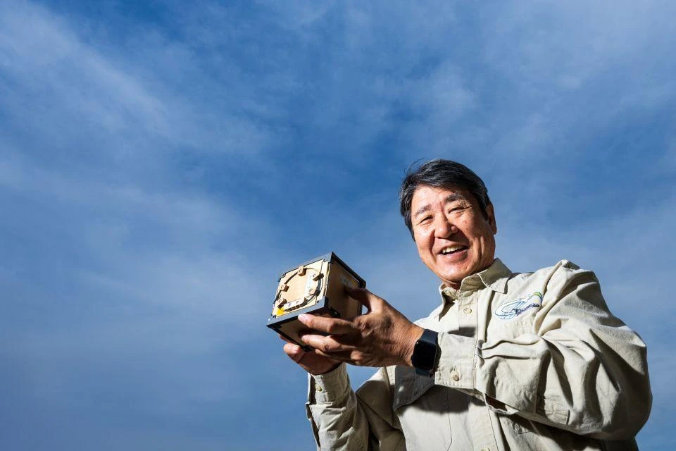 Astronaut Doi Takao holding the LignoSat wooden satellite