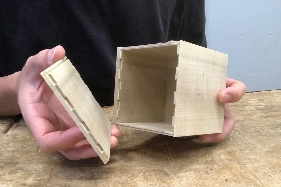 A person holding the wooden outer section of the LignoSat, which is made using an ancient Japanese joinery technique