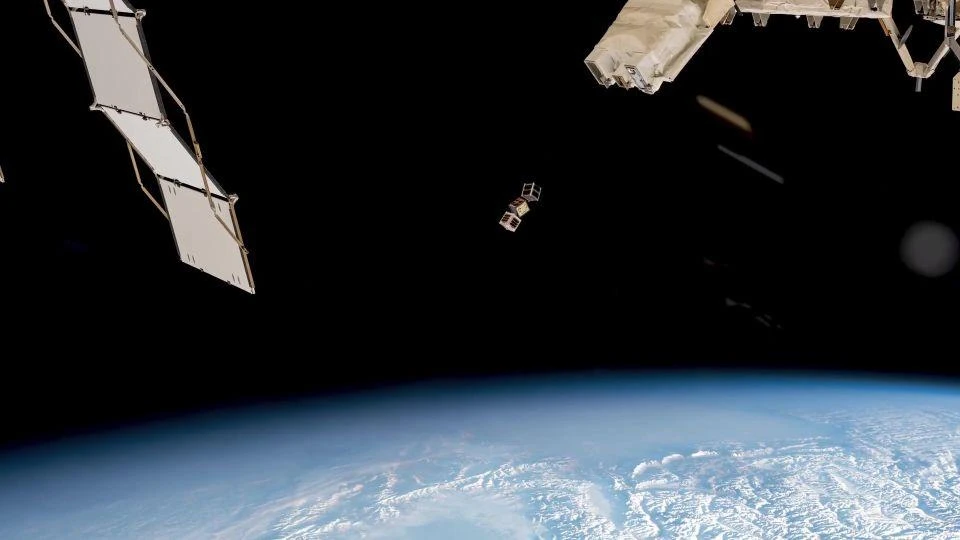 Image taken from space of the LignoSat being released from the International Space Station, with the Earth appearing below