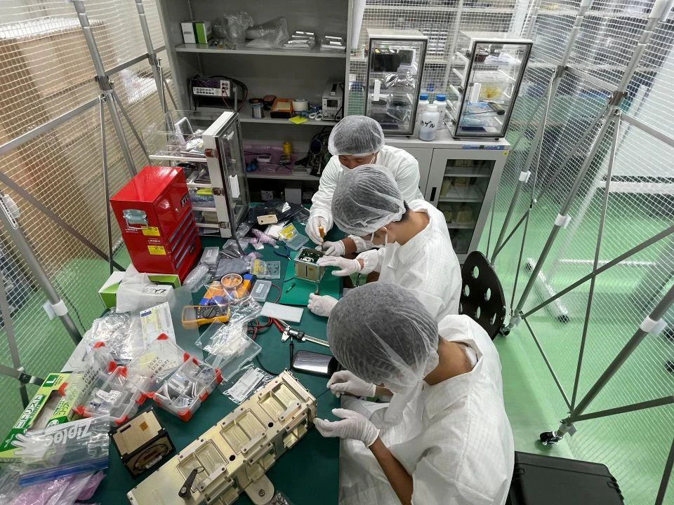 Students working on the wooden satellite.