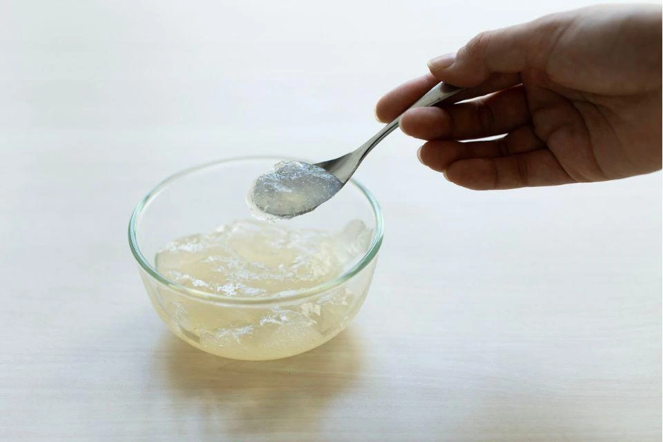 A glass bowl filled with Ninja Paste, with someone showing a spoonful of the substance