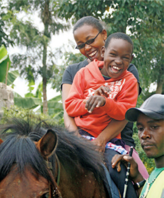 A mother and a child enjoy horse riding while on an excursion organized by the Garden.
