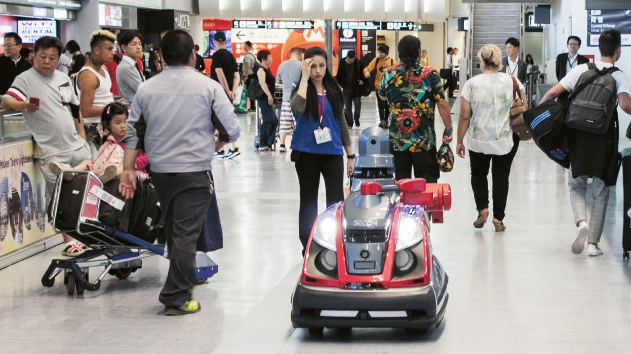 Four security robots are operating at Narita International Airport. The robots maneuver by themselves among airport users while giving the warning “patrolling.”