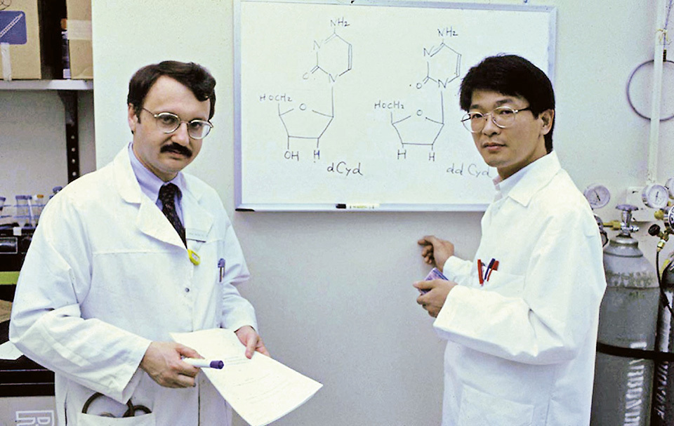 In 1984, working under supervisor Dr. Samuel Broder (left), Dr. Mitsuya commenced research to develop anti-HIV medication at the National Institutes of Health (NIH) in the United States.