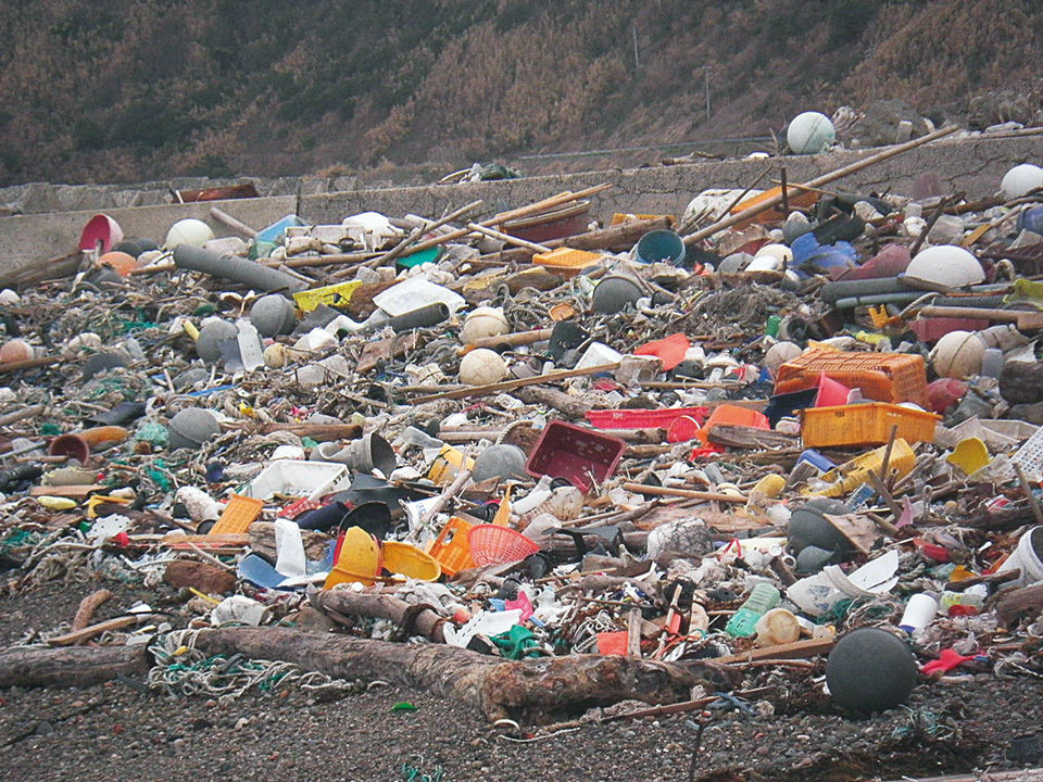 A huge amount of garbage drifts ashore onto the beaches of Wajima City. Much of the plastic waste has labels with text from non-Japanese languages.