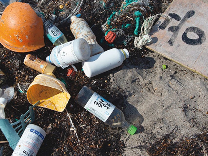A huge amount of garbage drifts ashore onto the beaches of Wajima City. Much of the plastic waste has labels with text from non-Japanese languages.