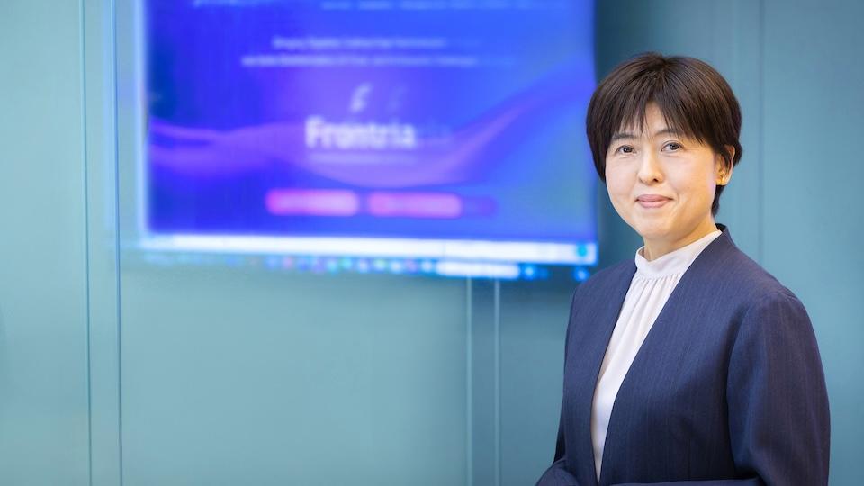 Izumi Nitta of Fujitsu standing in front of the Frontria log